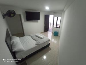 a bedroom with a bed and a flat screen tv at HOTEL SENDERO LAS GACHAS in Guadalupe