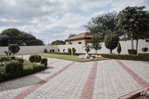 due persone stese su un vialetto in mattoni in un giardino di Mmaset Houses bed and breakfast a Gaborone