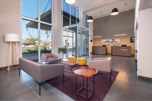 - un hall de bureau avec des chaises et une table dans l'établissement City Express by Marriott Chihuahua, à Chihuahua