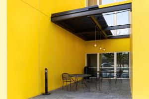 a yellow wall with chairs and a table in a room at City Express by Marriott Chihuahua in Chihuahua