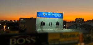 um sinal no topo de um edifício com o pôr-do-sol ao fundo em Hotel Supreme - Pistão Sul - Próximo ao Taguatinga Shopping em Taguatinga