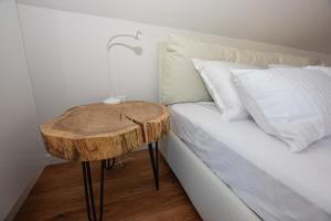 - un lit avec une table en bois à côté d'un lit dans l'établissement EROS APARTMENT Kranjska Gora, à Kranjska Gora