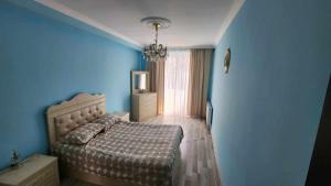 Un dormitorio azul con una cama y una ventana. en Apartment LL, en Kutaisi