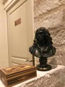 Un buste d'une femme assise sur un mur dans l'établissement Chambre Haute mer, à Montpellier