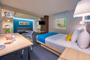 a hotel room with a bed and a desk at City Express by Marriott Suites Toluca in Toluca