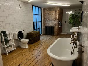 a bathroom with a tub and a toilet and a sink at Bedford Street Lofts in Leamington Spa +46 photos