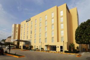 a large yellow building with a sign on it at City Express by Marriott Tijuana Insurgentes in Tijuana