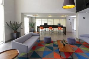 a living room with a couch and a table at City Express by Marriott Tijuana Insurgentes in Tijuana