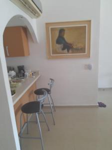 a kitchen with two stools and a painting on the wall at airbnb Acapulco Diamante in Acapulco