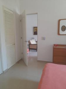 a white bedroom with a bed and a room with a bed sqor at airbnb Acapulco Diamante in Acapulco +8 photos