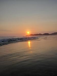 a sunset on a beach with the ocean at airbnb Acapulco Diamante in Acapulco