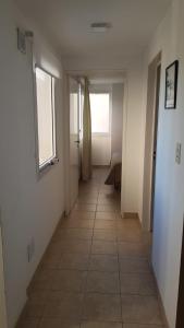 a hallway with a tile floor and a window at Departamento luminoso en Neuquén in Neuquén