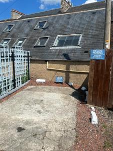 a house with a fence and a sign on it at Teviot View Holiday Let’s Hawick in Hawick