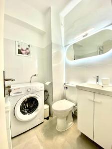 a bathroom with a washing machine and a toilet at Union Experience - City Center in Timişoara