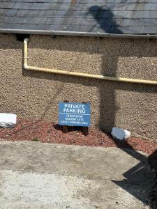 een bord met een eigen parkeerplaats aan de zijkant van een gebouw bij Teviot View Holiday Let’s Hawick in Hawick