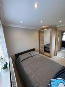 - une chambre avec un grand lit et un miroir dans l'établissement Charming 1-Bedroom Retreat for up to 4 Guests, à Windsor