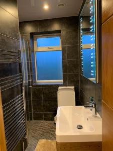 La salle de bains est pourvue d'un lavabo, de toilettes et d'une fenêtre. dans l'établissement Charming 1-Bedroom Retreat for up to 4 Guests, à Windsor