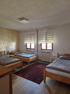 a room with three beds and two windows at Apartman "EXCLUSIVE" in Bihać