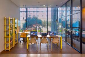 a room with a table and chairs and a large window at City Express Suites by Marriott Tijuana Rio in Tijuana