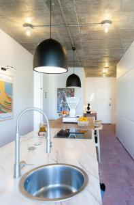 uma cozinha com um lavatório e duas luzes pendentes em Columbano Suites Accomodations Lisboa - Praça de Espanha, Sete Rios - Bookable parking em Lisboa
