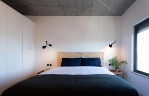 sypialnia z dużym łóżkiem z niebieskimi poduszkami w obiekcie Columbano Suites Hotel Lisboa - Praça de Espanha, Sete Rios - Bookable parking w Lizbonie