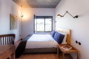 sypialnia z łóżkiem, stołem i oknem w obiekcie Columbano Suites Hotel Lisboa - Praça de Espanha, Sete Rios - Bookable parking w Lizbonie