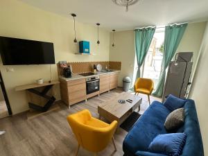 a living room with a blue couch and a tv at Résidence le Marcadieu in Tarbes