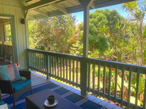 um alpendre coberto com vista para as árvores em Seaside House and Aloha Bungalow em Pahoa