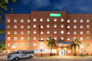 ein Gebäude mit einem Van davor in der Unterkunft City Express Junior by Marriott Villahermosa in Villahermosa