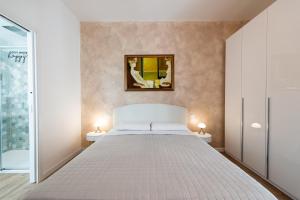 a bedroom with a bed and a mirror on the wall at CIVICO 11 PERUGIA Accogliente trilocale per 4 persone con 2 bagni e posto auto riservato in Perugia