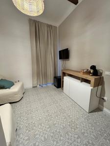um quarto com uma cama, uma secretária e uma televisão em Casa la cava em Taranto