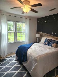 een slaapkamer met een bed en een plafondventilator bij Cottage by the Beach Best Suited for Large Groups in Wilmington