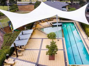 an overhead view of a swimming pool with a tent at Grand Mercure the Vintage, Accor Vacation Club Apartments in Rothbury