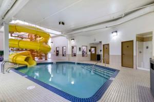 a large swimming pool with a slide in a building at Best Western Rocky Mountain House Inn & Suites in Rocky Mountain House