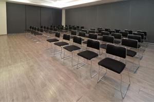 une chambre avec une rangée de chaises et de tables dans l'établissement City Express Plus by Marriott Monterrey Galerías, à Monterrey