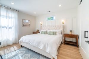 Un dormitorio blanco con una cama grande y una ventana en Reno Dream Cottage: Delightful 2-Bedroom Sanctuary, en Reno