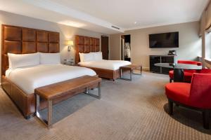 Cette chambre comprend 2 lits et une télévision. dans l'établissement The May Fair, A Radisson Collection Hotel, Mayfair London, à Londres
