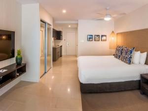 een hotelkamer met een bed en een televisie bij The Sebel Palm Cove in Palm Cove