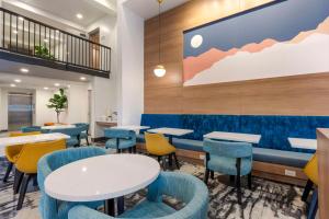 a dining room with tables and chairs and a wall at Aiden by Best Western Flagstaff in Flagstaff