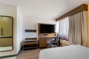 Habitación de hotel con cama y escritorio con TV. en Aiden by Best Western Flagstaff en Flagstaff