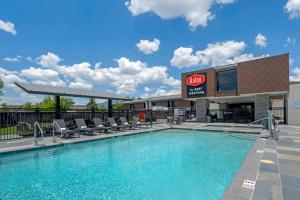 a swimming pool with chairs and a building at Aiden by Best Western Flagstaff in Flagstaff