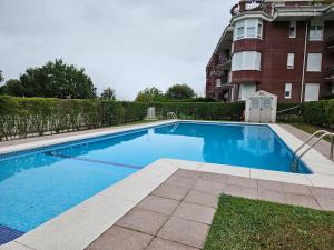 a large blue swimming pool in front of a building at C03A02 Apartamento con piscina y garaje in Cicero