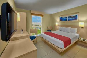 1 dormitorio con 1 cama y TV de pantalla plana en City Express by Marriott Campeche, en Campeche