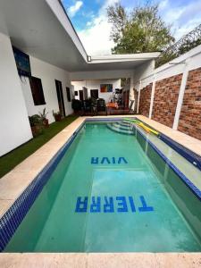 a swimming pool with blue water in front of a house at Casa Tierra Viva in Managua