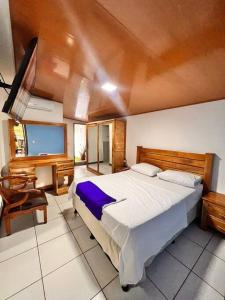 a bedroom with a large bed and a desk at Casa Tierra Viva in Managua