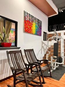 2 Stühle in einem Zimmer mit Wandgemälde in der Unterkunft Casa Tierra Viva in Managua