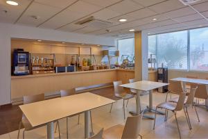 サルティーヨにあるCity Express by Marriott Saltillo Surのテーブルと椅子のあるレストラン、キッチンが備わります。