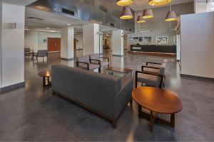 a lobby with a couch and tables and chairs at City Express by Marriott Irapuato Norte in Irapuato