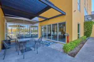 a patio with tables and chairs and a building at City Express by Marriott Irapuato Norte in Irapuato