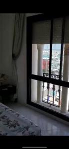 a bedroom with a window with a view of a bridge at Grand appartement vue sur port à Marina smir in M'diq
